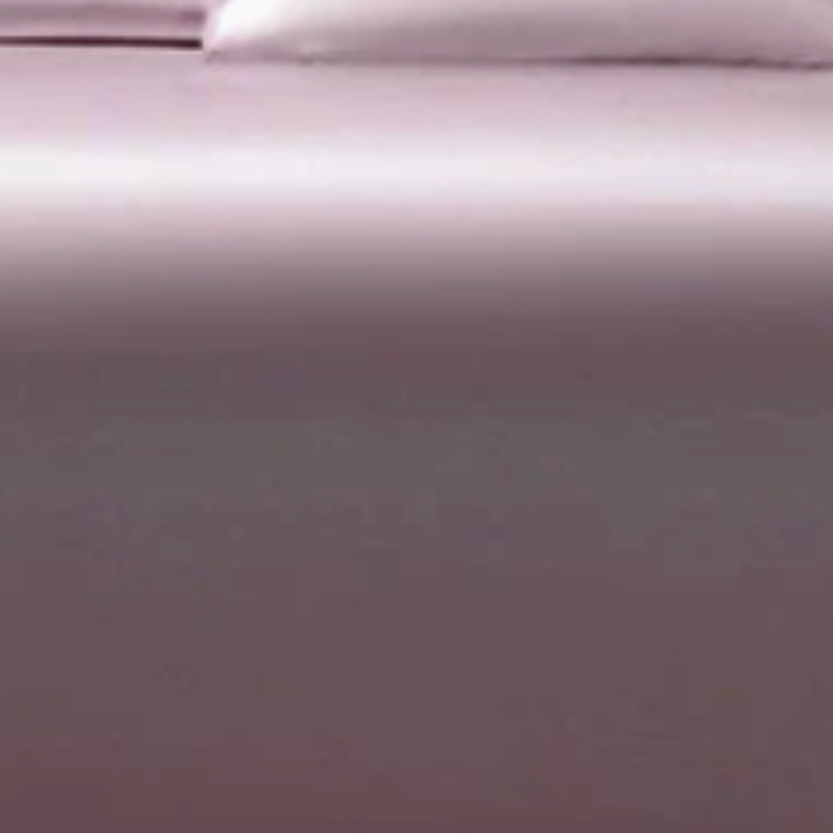 A close-up of a smooth, solid-colored fabric surface in a muted mauve or dusty purple tone, with a soft lighter area at the top edge.