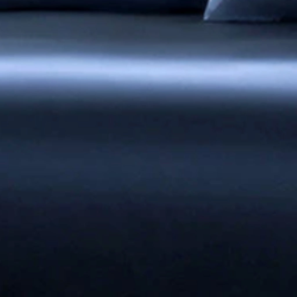 A close-up of a dark navy blue fabric surface with a soft horizontal light reflection across the middle.