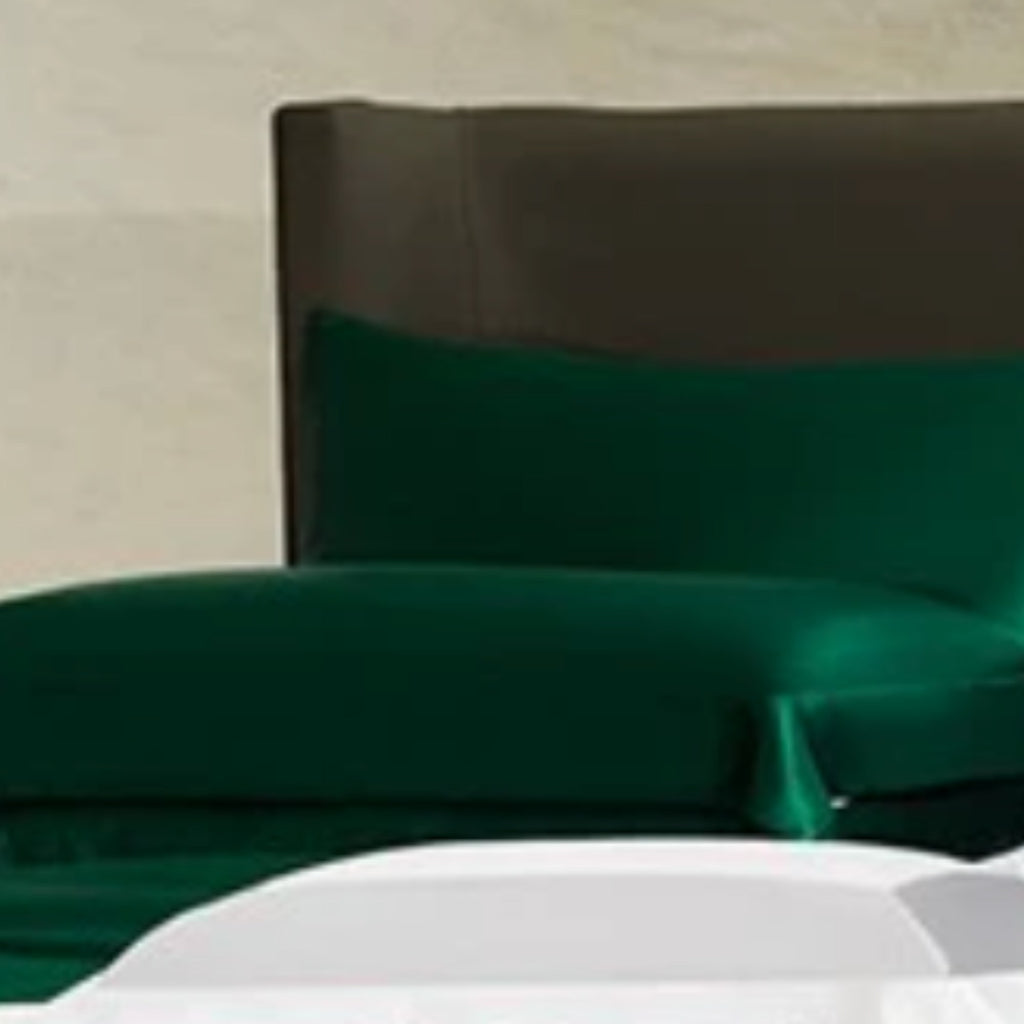 Emerald green silk duvet cover and fitted sheet set with matching pillowcases, showcasing a smooth, elegant finish.