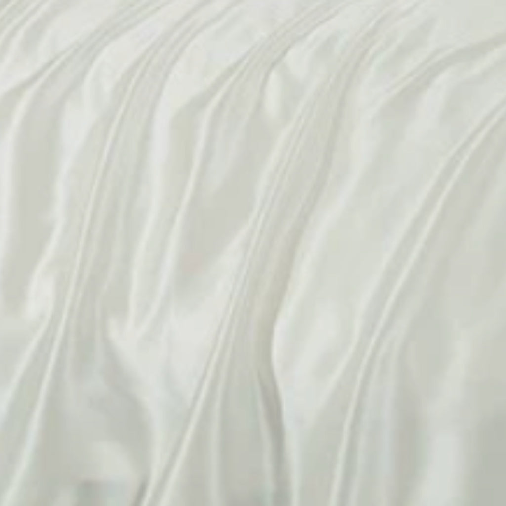 A close-up of draped white fabric with soft folds and a smooth, slightly lustrous texture.