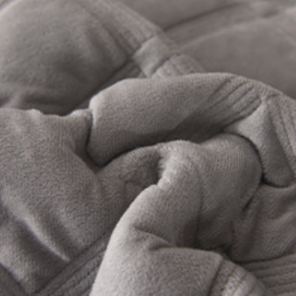 Close-up of a soft gray plush fabric with stitched folds and a textured surface.