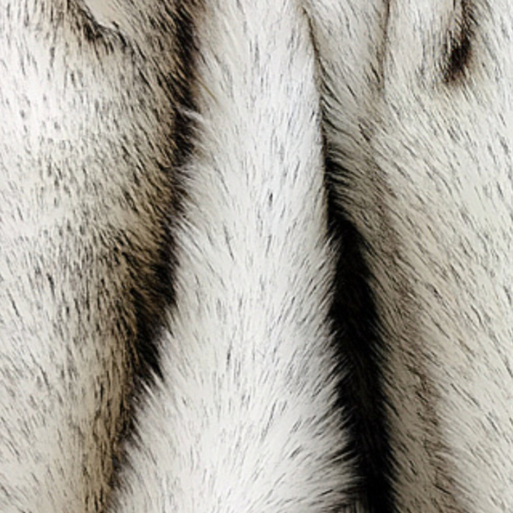 Close-up of a faux fur or animal print fabric with textured vertical stripes in off-white, gray, and black.