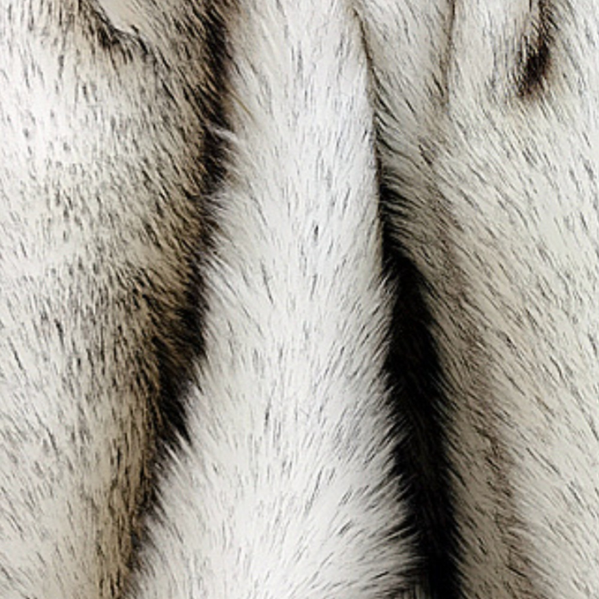 Close-up of a faux fur or animal print fabric with textured vertical stripes in off-white, gray, and black.