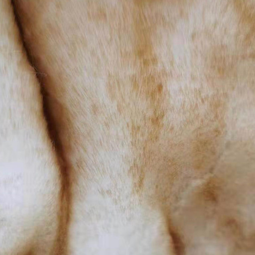 A close-up texture shot of a soft, light tan or cream-colored fabric with fine, slightly matted fibers.