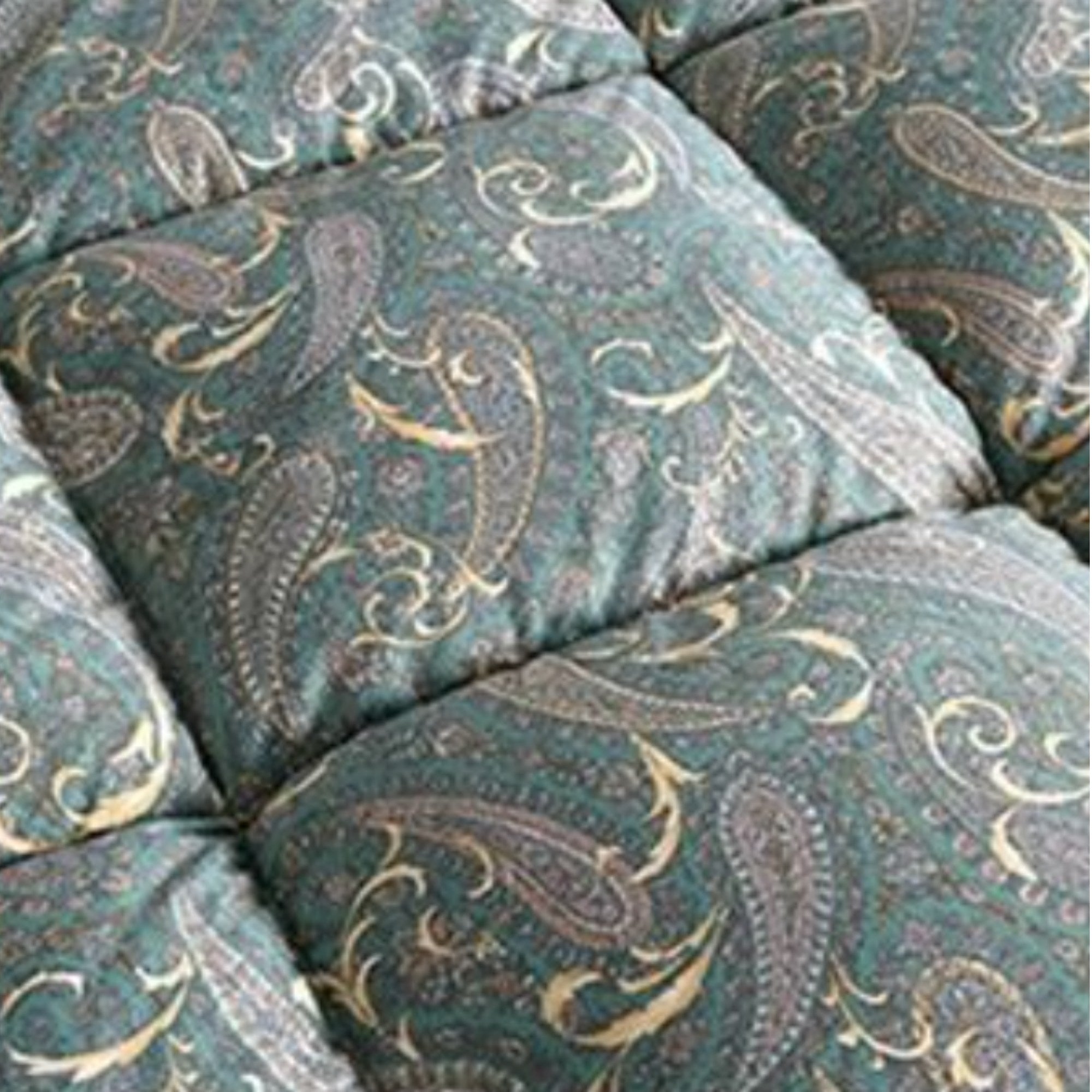 Close-up of a quilted cushion or upholstered panel with a teal-green background and an ornate paisley pattern in beige, gray, and muted blue.