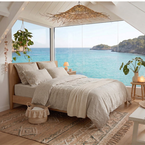 Bedroom with ocean view, wooden bed, and natural light