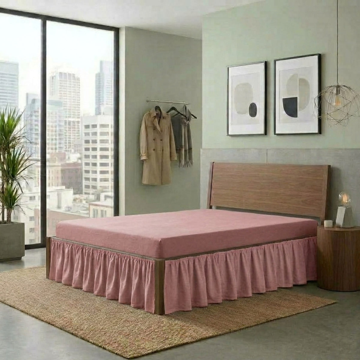 A bed with a dusty pink mattress and matching skirted bed frame in a modern bedroom setting with a city view, wood headboard, and a woven rug.