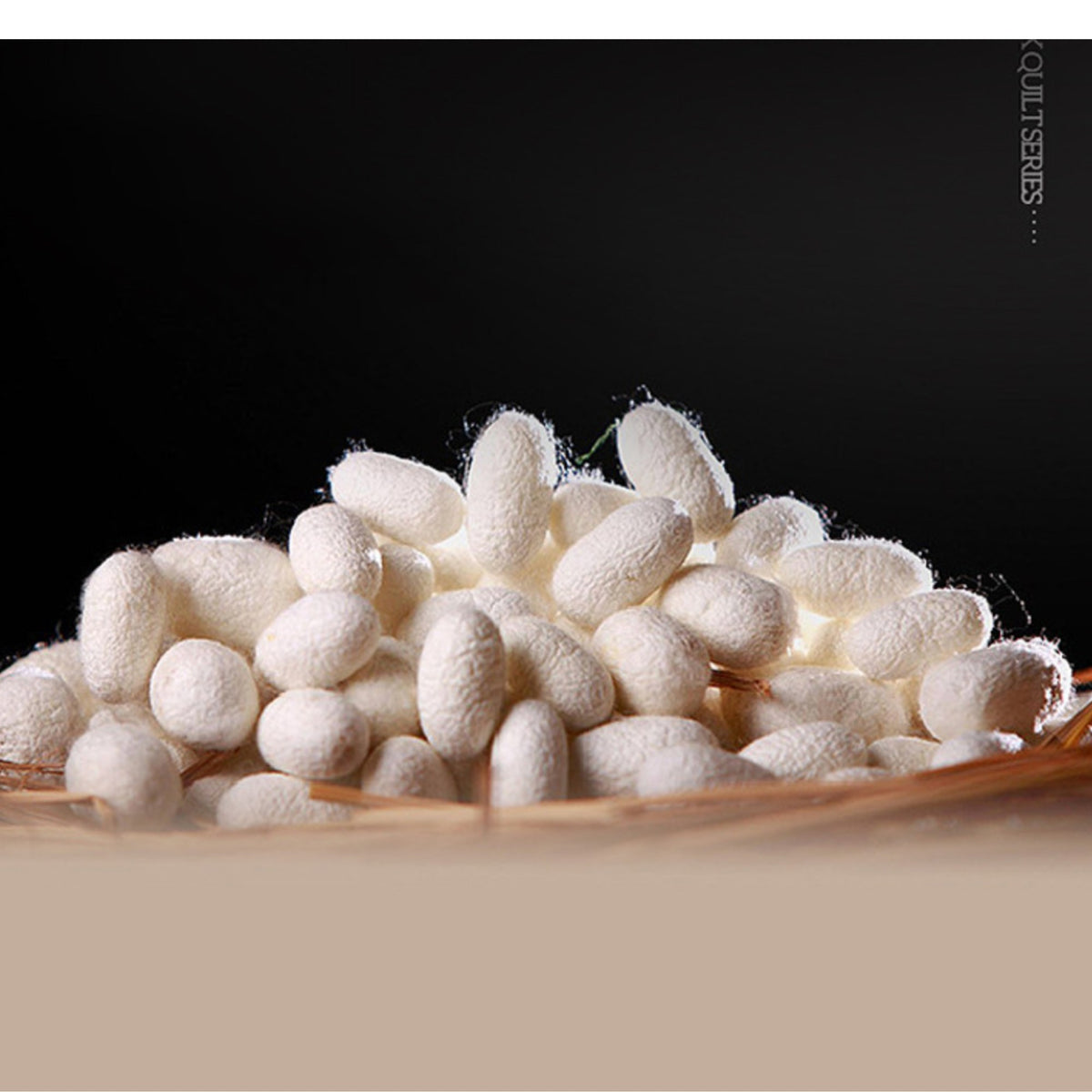 A pile of off-white silk cocoons or fibrous textile pieces resting on a woven straw basket against a black background, with a beige foreground band and vertical text reading 'SCALPERS.